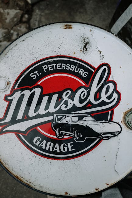 Close-up of St. Petersburg Muscle Garage logo on a round metal surface.
